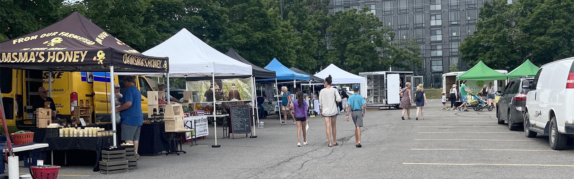 Photo of several vendors at the outdoor Masonville Market.