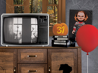 A red balloon, a Chucky doll, an old tube TV with hands pressed against a window showing and an illustration of a stack of VHS tapes with a pumpkin on top with the number thirty-one carved into it.