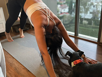 A photo of a woman doing exercises inside an apartment.