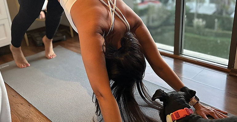 A photo of a woman doing exercises inside an apartment.